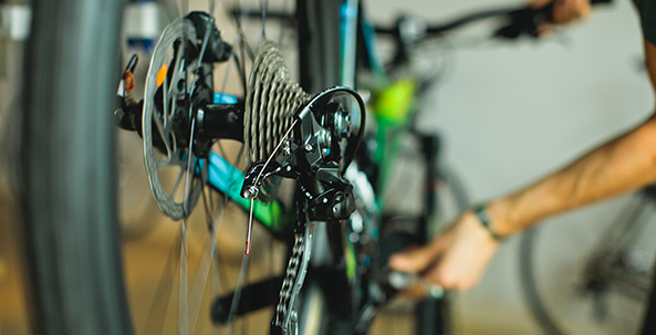 A person is working on a bicycle in a shop.