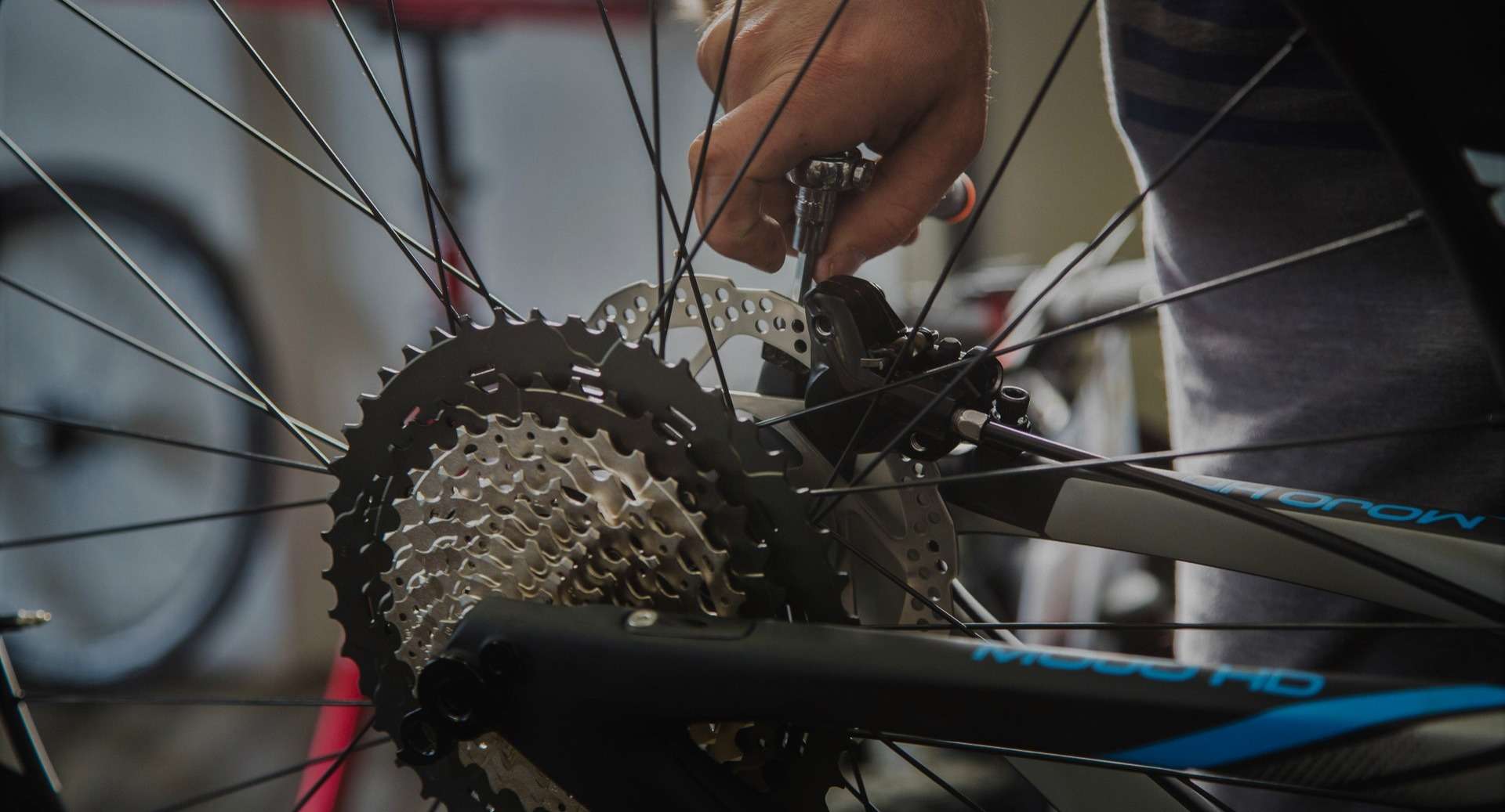 A person is working on a bicycle wheel.