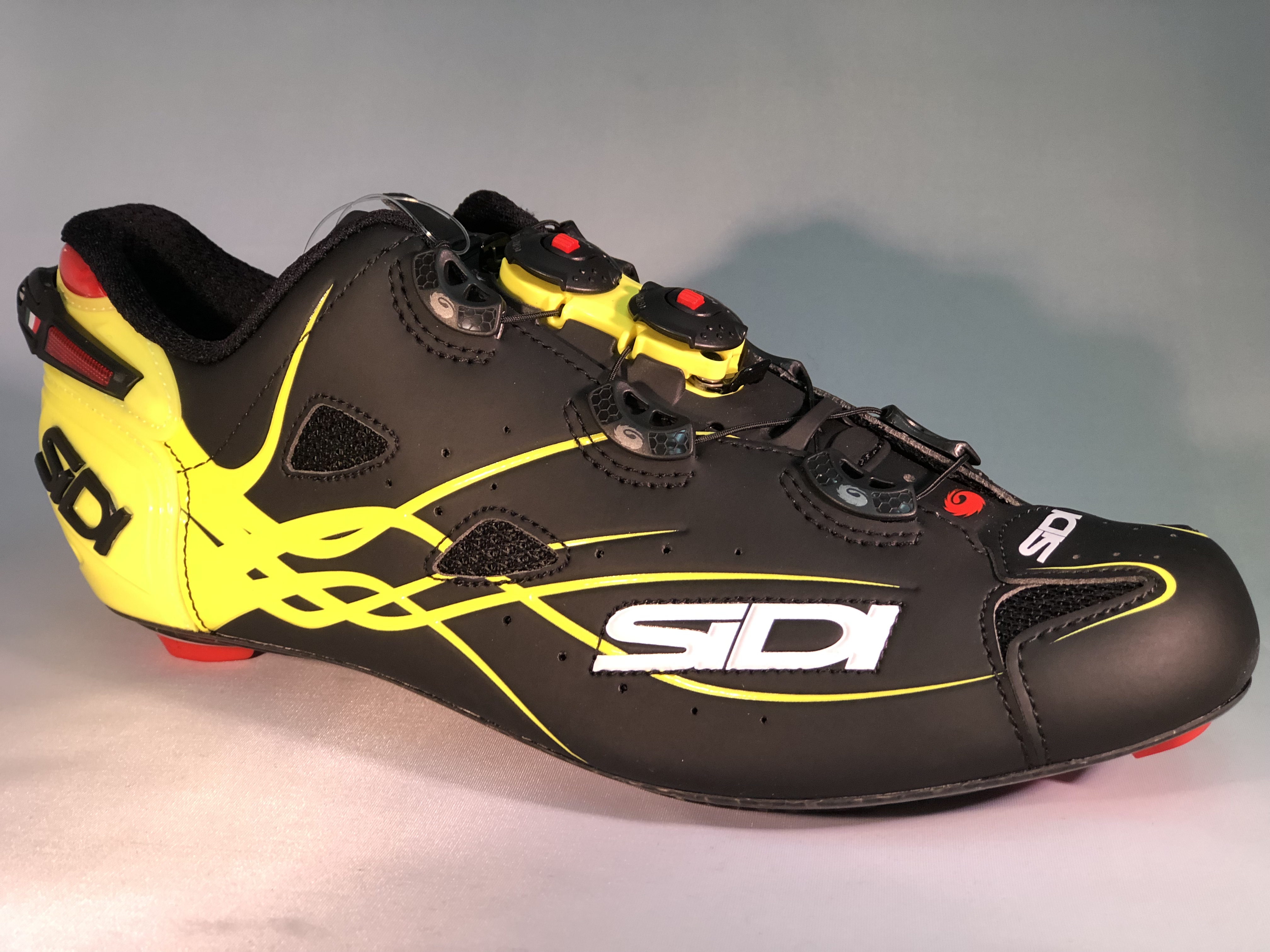 A pair of black and yellow cycling shoes.