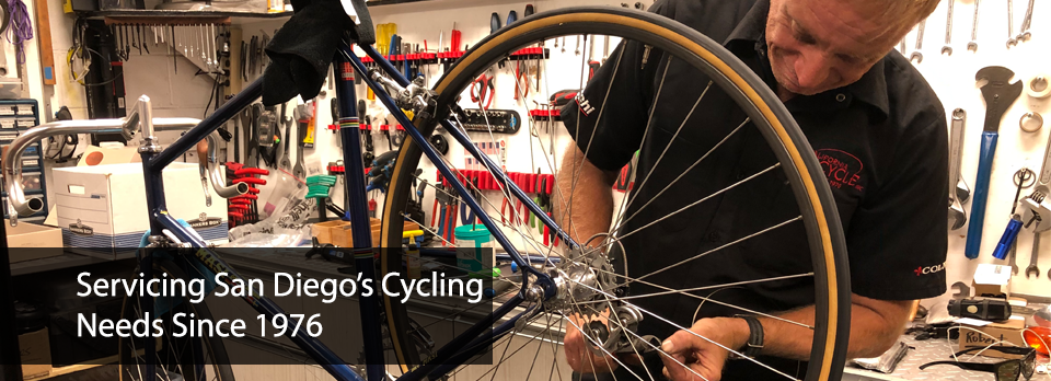 A man is working on a bicycle in a shop.